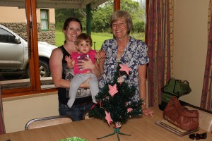 Mom, gran, and daughter setting up the Christmas tree