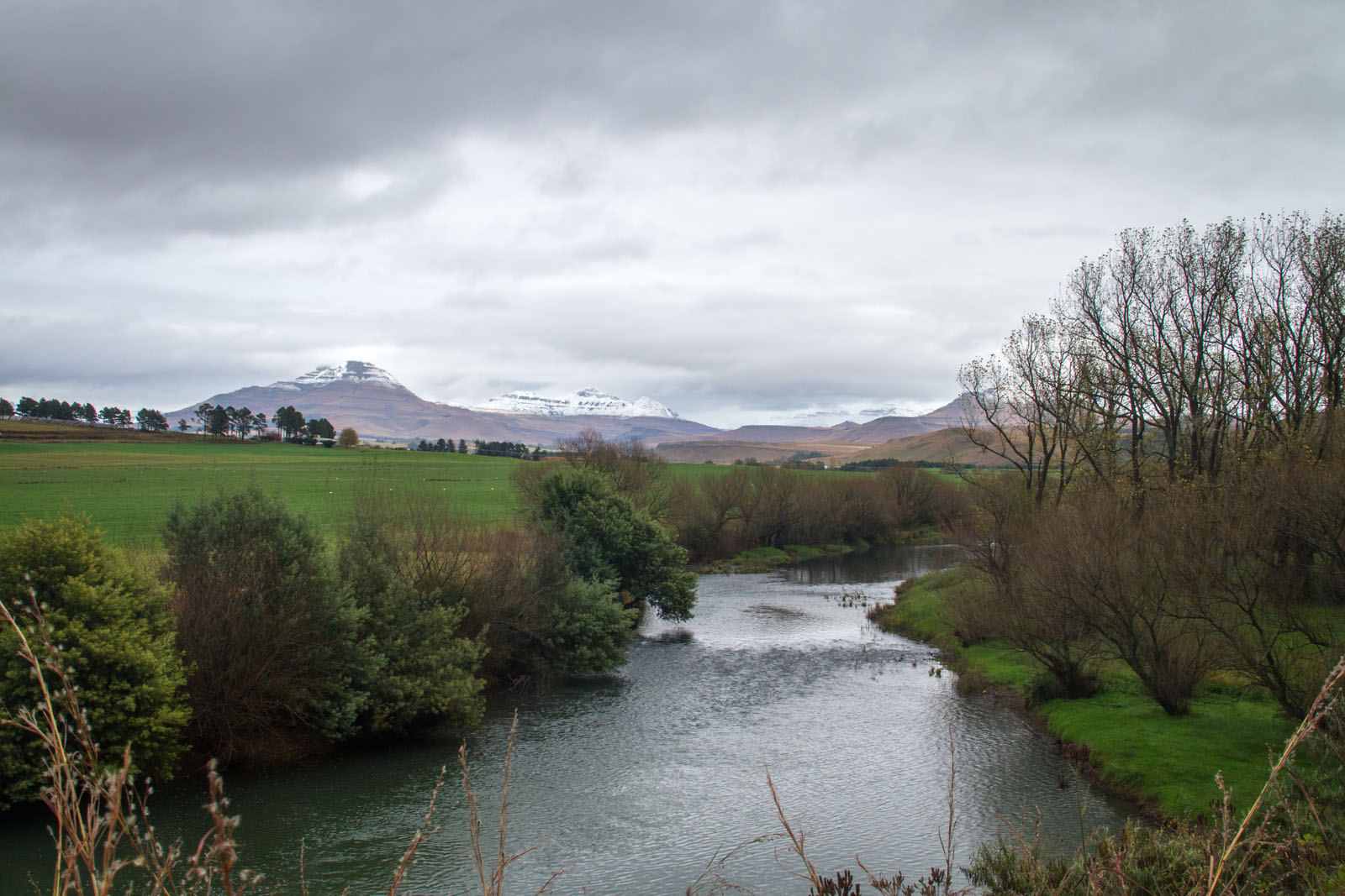 View of the snow capped mountains towering above Sinister Pool on the Umzimkulu River, Underberg