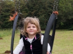 Emma enjoying the swings